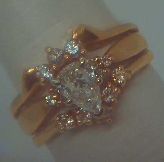Picture of 14kt yellow gold wedding ring soldered together with diamonds ( 1 centered pear shaped diamond 0.39pt  & 14 round diamonds 0.40pts ) 5.7gr size 8.  very good condition. i-5953. 