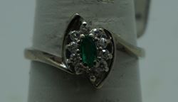 Picture of 14kt white gold ring size 7.5 2.8gr with 10 round diamonds 0.25pts  and marquise emerald 0.10pts. pre owned. very good condition.